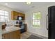 Efficient kitchen with wood cabinets and black appliances near a bright window at 9788 Pine Ridge North Dr, Fishers, IN 46038