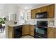 Functional kitchen featuring wood cabinetry, black appliances and laminate countertops at 9788 Pine Ridge North Dr, Fishers, IN 46038