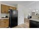 Cozy kitchen view to the living room showing wood cabinets and black appliances at 9788 Pine Ridge North Dr, Fishers, IN 46038