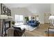 Open-concept living room with fireplace, wood floors and a sliding door to the backyard at 9788 Pine Ridge North Dr, Fishers, IN 46038