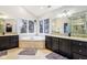 Bathroom boasts a soaking tub between two vanities with dark cabinets and granite counter tops, surrounded by windows at 9956 Hickory Ridge Dr, Zionsville, IN 46077