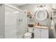 Charming bathroom with glass shower, floating shelves, round mirror and a small vanity sink at 9956 Hickory Ridge Dr, Zionsville, IN 46077