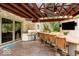 Outdoor kitchen area with stainless steel grill, bar seating, and covered patio at 9956 Hickory Ridge Dr, Zionsville, IN 46077