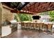 Covered outdoor kitchen area with built-in grill, bar, and spacious patio at 9956 Hickory Ridge Dr, Zionsville, IN 46077