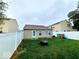 A private backyard, featuring a well-manicured lawn, white fencing, and play equipment at 10921 Walnut Grv, Camby, IN 46113