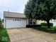 Charming home featuring a two-car garage, a spacious driveway, and a beautifully landscaped front yard at 10921 Walnut Grv, Camby, IN 46113