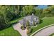 Stunning aerial view of a grand estate with lush landscaping, a circular driveway, and serene lake views at 11620 Willow Springs Dr, Zionsville, IN 46077