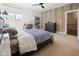 This bedroom features a stylish accent wall, a ceiling fan, and a comfortable bed with unique patterned bedding at 11620 Willow Springs Dr, Zionsville, IN 46077