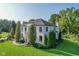 Expansive lawn surrounds this elegant home featuring dark trim and mature trees at 11620 Willow Springs Dr, Zionsville, IN 46077