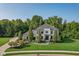 Beautiful two-story home featuring lush landscaping, dark trim, and a symmetrical facade at 11620 Willow Springs Dr, Zionsville, IN 46077