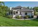 Manicured lawn surrounds this stately home with a covered porch and a three-car garage at 11620 Willow Springs Dr, Zionsville, IN 46077
