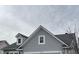 Close up of the roofline showcasing architectural design with dormer windows, gray siding, and a neutral roof at 12075 Sugar Creek Rd, Noblesville, IN 46060