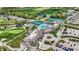 An aerial view shows tennis courts and a pool at the community center surrounded by lush greenery at 1225 Stonehaven Dr, Westfield, IN 46074