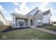 Beautifully landscaped yard and brick home with a cozy covered porch including seating to enjoy the outdoors at 1225 Stonehaven Dr, Westfield, IN 46074