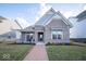 Charming brick home featuring a covered porch with seating, landscaping, and a welcoming brick pathway to the front door at 1225 Stonehaven Dr, Westfield, IN 46074