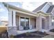 Inviting covered front porch with seating, featuring stylish brickwork and manicured landscaping, creating a welcoming entrance at 1225 Stonehaven Dr, Westfield, IN 46074
