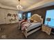 Spacious main bedroom with a chandelier, tray ceiling, and a walk-in closet at 12889 Girvan Way, Fishers, IN 46037