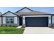 Charming single-story home featuring white siding, black accents, and a two-car garage on a sunny day at 1414 Bluebonnet Pl, Shelbyville, IN 46176