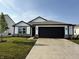 Charming single-story home with a well-manicured lawn, black trim, and black garage door at 1414 Bluebonnet Pl, Shelbyville, IN 46176