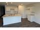Bright kitchen featuring a large island with a double sink, white cabinets, and wood-look floors at 1414 Bluebonnet Pl, Shelbyville, IN 46176