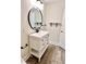 Bathroom featuring a white vanity with a black round mirror and modern fixtures at 1427 Broyles Ln, Indianapolis, IN 46231