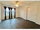 Bedroom featuring dual closets, dark wood-look floors, and large windows with black curtains at 1427 Broyles Ln, Indianapolis, IN 46231