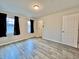 Spacious bedroom featuring wood-look flooring, two windows with dark curtains and neutral walls at 1427 Broyles Ln, Indianapolis, IN 46231