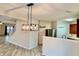 Bright dining area with modern light fixture, white brick accent wall, and open access to living spaces at 1427 Broyles Ln, Indianapolis, IN 46231