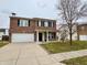 Two-story brick home with a well-manicured lawn, two-car garage, and a welcoming front porch at 1427 Broyles Ln, Indianapolis, IN 46231