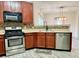 Kitchen with stainless steel appliances, dark wood cabinets, and open view to the living area at 1427 Broyles Ln, Indianapolis, IN 46231