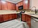 Well-appointed kitchen featuring wood cabinets, modern appliances, and durable vinyl flooring at 1427 Broyles Ln, Indianapolis, IN 46231