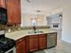 Efficient kitchen featuring dark wood cabinets, stainless steel appliances, and tiled backsplash at 1427 Broyles Ln, Indianapolis, IN 46231