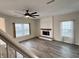 Spacious living room with a ceiling fan, a fireplace, and large windows offering natural light at 1427 Broyles Ln, Indianapolis, IN 46231
