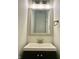 Charming powder room featuring a vanity with black hardware and a framed mirror with decorative lighting at 1427 Broyles Ln, Indianapolis, IN 46231