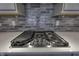 Close-up of a Monogram gas cooktop with a gray backsplash at 16822 Imperial Ct, Fishers, IN 46040