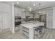 Bright kitchen featuring a center island, gray cabinets, stainless steel appliances, and modern lighting at 16822 Imperial Ct, Fishers, IN 46040