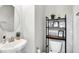 Stylish half bath with a pedestal sink, round mirror, and decorative shelving adding visual interest at 1835 Fairmount Dr, Greenfield, IN 46140