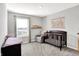 Calm Bedroom with grey rocking chair, crib, and bright window at 1835 Fairmount Dr, Greenfield, IN 46140