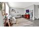 Bright and airy living room with gray walls, modern sectional sofa, and stylish decor and wood-look floors at 1835 Fairmount Dr, Greenfield, IN 46140