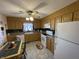 Cozy eat-in kitchen with a ceiling fan, oak cabinets, white appliances, and tile flooring at 2130 Theobald St, Shelbyville, IN 46176
