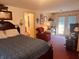 Comfortable bedroom with a bed, red armchair, and door leading to the backyard at 2317 Lincoln Dr, Cicero, IN 46034
