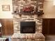 Cozy brick fireplace with gas insert, flanked by wood paneling and decorative mantel at 2317 Lincoln Dr, Cicero, IN 46034