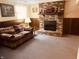 Cozy living room with decorative brick fireplace, wood paneling, and carpeted floor at 2317 Lincoln Dr, Cicero, IN 46034