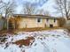 The backyard has a snow-covered yard with a brick house in the background at 2613 E 7Th St, Anderson, IN 46012