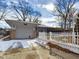 The exterior features a garage and home with a white fence and wintry scenery at 2613 E 7Th St, Anderson, IN 46012