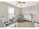 ' bedroom featuring a crib, a rocking chair, carpet flooring, and a ceiling fan at 2792 Maricopa Blvd, Whitestown, IN 46075
