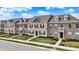 Beautiful townhomes with brick facade, dormer windows and manicured lawns on a sunny day at 2792 Maricopa Blvd, Whitestown, IN 46075