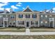 Charming townhome featuring light brick, black shutters, dormer windows, and well-maintained landscaping at 2792 Maricopa Blvd, Whitestown, IN 46075