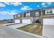 View of townhomes showing attached garages, neutral siding, and lawns at 2792 Maricopa Blvd, Whitestown, IN 46075