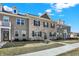 Beautiful townhome exterior featuring brick, dormer windows, well-kept landscaping, and blue skies at 2792 Maricopa Blvd, Whitestown, IN 46075